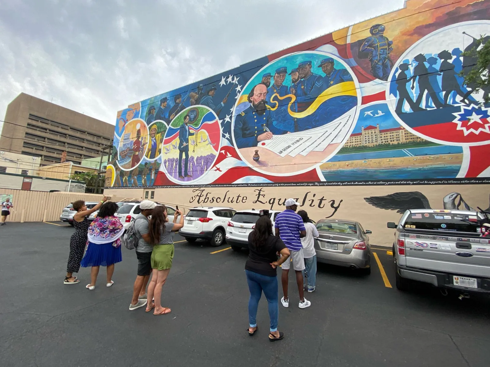Visitors pointing their phones at the Absolute Equality mural in Galveston, Texas.